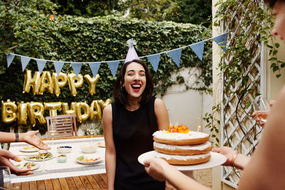 Smiling woman celebrating birthday at yard