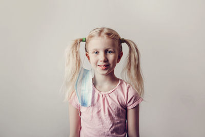 Portrait of cute girl standing against white background