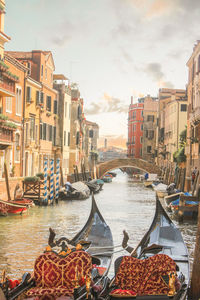 Boats moored in canal against buildings in city