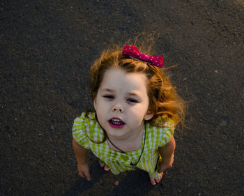 High angle portrait of cute girl standing on road