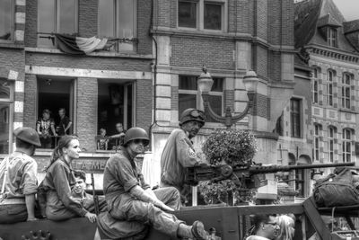 People on street against buildings in city