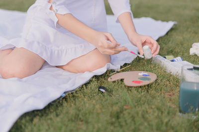 Midsection of woman holding umbrella on field