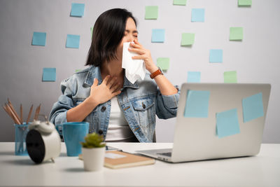 Thoughful woman with eyes closed by objects on table