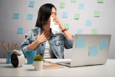 Thoughful woman with eyes closed by objects on table