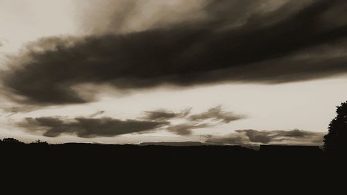 Scenic view of dramatic sky over silhouette landscape