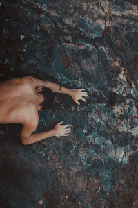 High angle view of shirtless man on rock