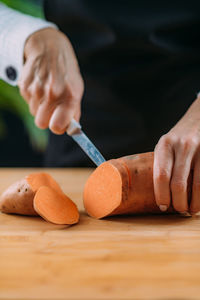 Cutting fresh organic sweet potato, superfood rich in tryptophan, potassium, vitamin c