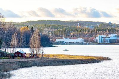 Scenic view of lake by buildings against sky