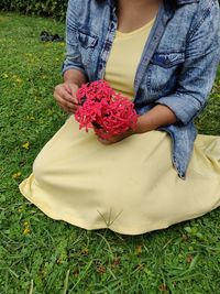 High angle view of woman holding flower on field