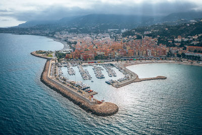 Aerial view of buildings by sea against sky