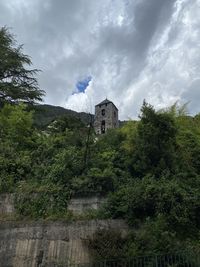Low angle view of trees and buildings against sky