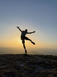 Full length of man jumping against sky during sunset