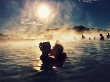 Couple kissing while swimming in hot spring