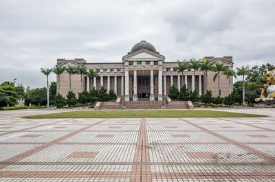 Facade of historical building against cloudy sky