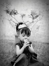 Portrait of young woman looking away while standing outdoors