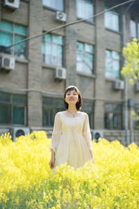 Woman standing in front of yellow flowering plants