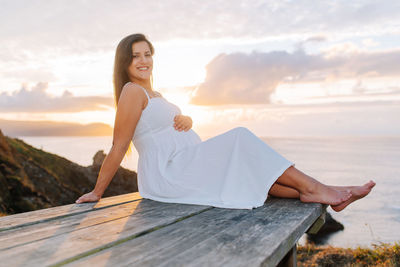 Young woman on beach against sky