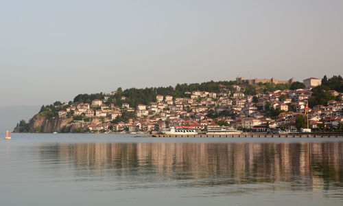 Townscape by sea against clear sky
