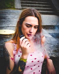 Portrait of beautiful young woman sitting outdoors