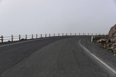 Surface level of empty road against clear sky