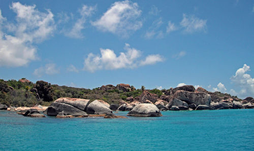 Rocks by sea against sky