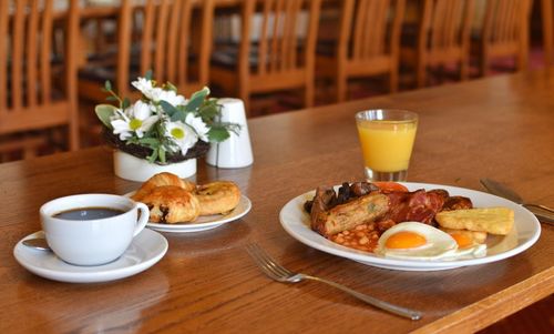 Full english breakfast with coffee, juice and french pastry 