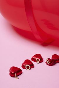 Heart-shaped candies on pink background