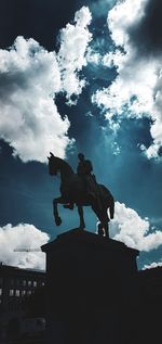 Low angle view of silhouette statue against sky