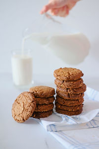 A stack of delicious homemade cookies with a glass of milk on the background