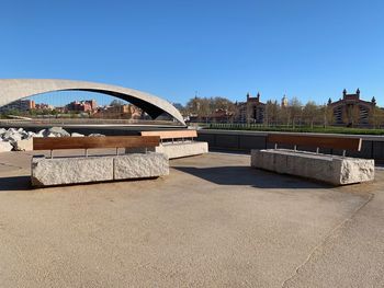 Bridge over river in city against clear sky