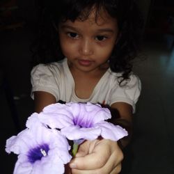 Portrait of a girl holding purple flower