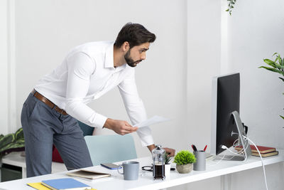 Side view of a young man using mobile phone
