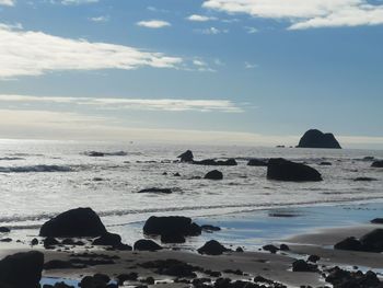 Scenic view of rocks in sea against sky