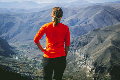 Rear view of woman standing against mountains