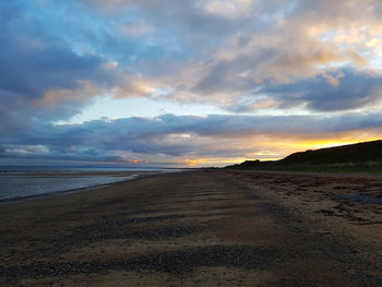 Scenic view of beach against sky during sunset