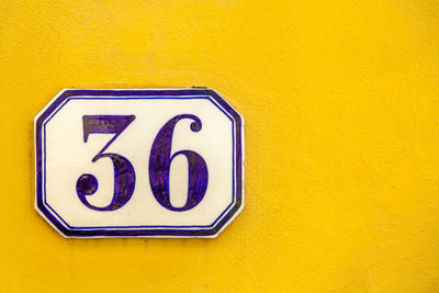 Close-up of number 36 on yellow wall
