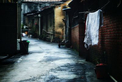 Alley amidst old houses during rainy season