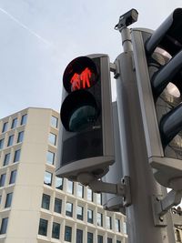 Low angle view of road signal against sky