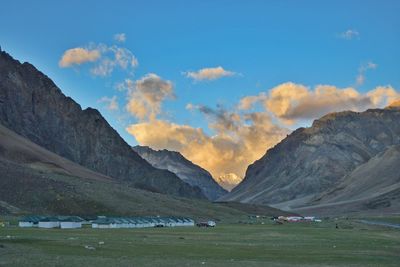 Scenic view of field and mountains against sky