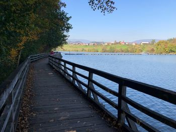 Bridge over calm river against sky