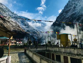 Scenic view of building by mountains against sky