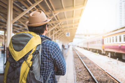 Rear view of man at railroad station