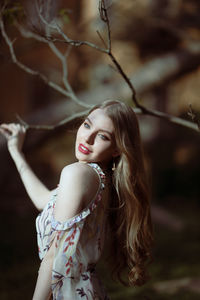 Beautiful young woman looking away while standing outdoors