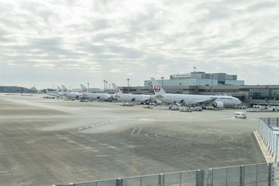 Airplane on airport runway against sky