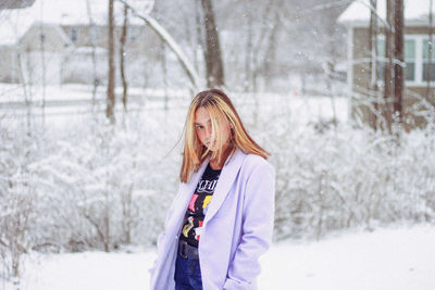 Young woman standing on snow covered field