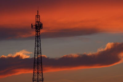 Low angle view of communications tower against sky during sunset