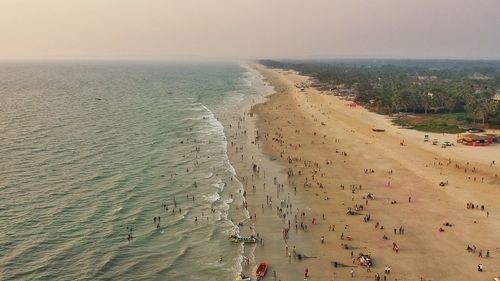 Aerial view of people at beach during sunset