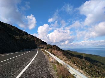 Road by mountain against sky