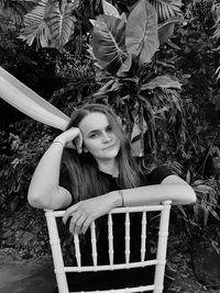 Portrait of woman sitting on plant