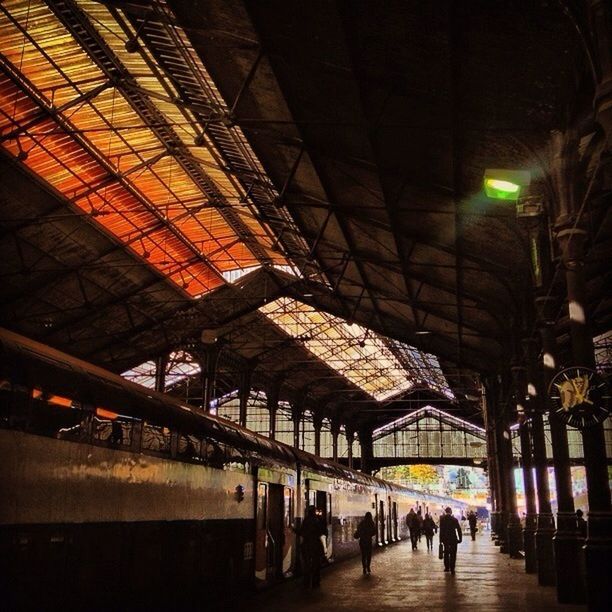 illuminated, railroad station, architecture, built structure, railroad station platform, transportation, indoors, men, walking, large group of people, public transportation, person, rail transportation, lifestyles, city life, railroad track, night, lighting equipment, subway station